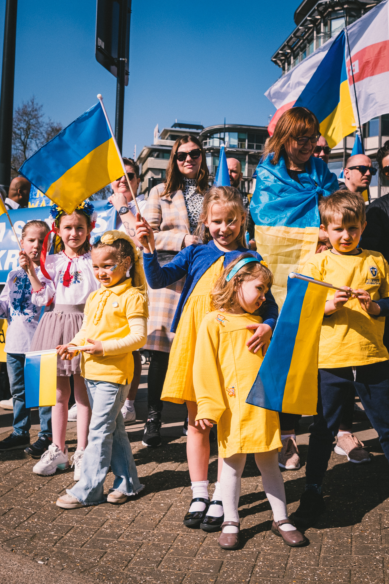 A group of children holding Ukrainian flags before the solidarity march begins