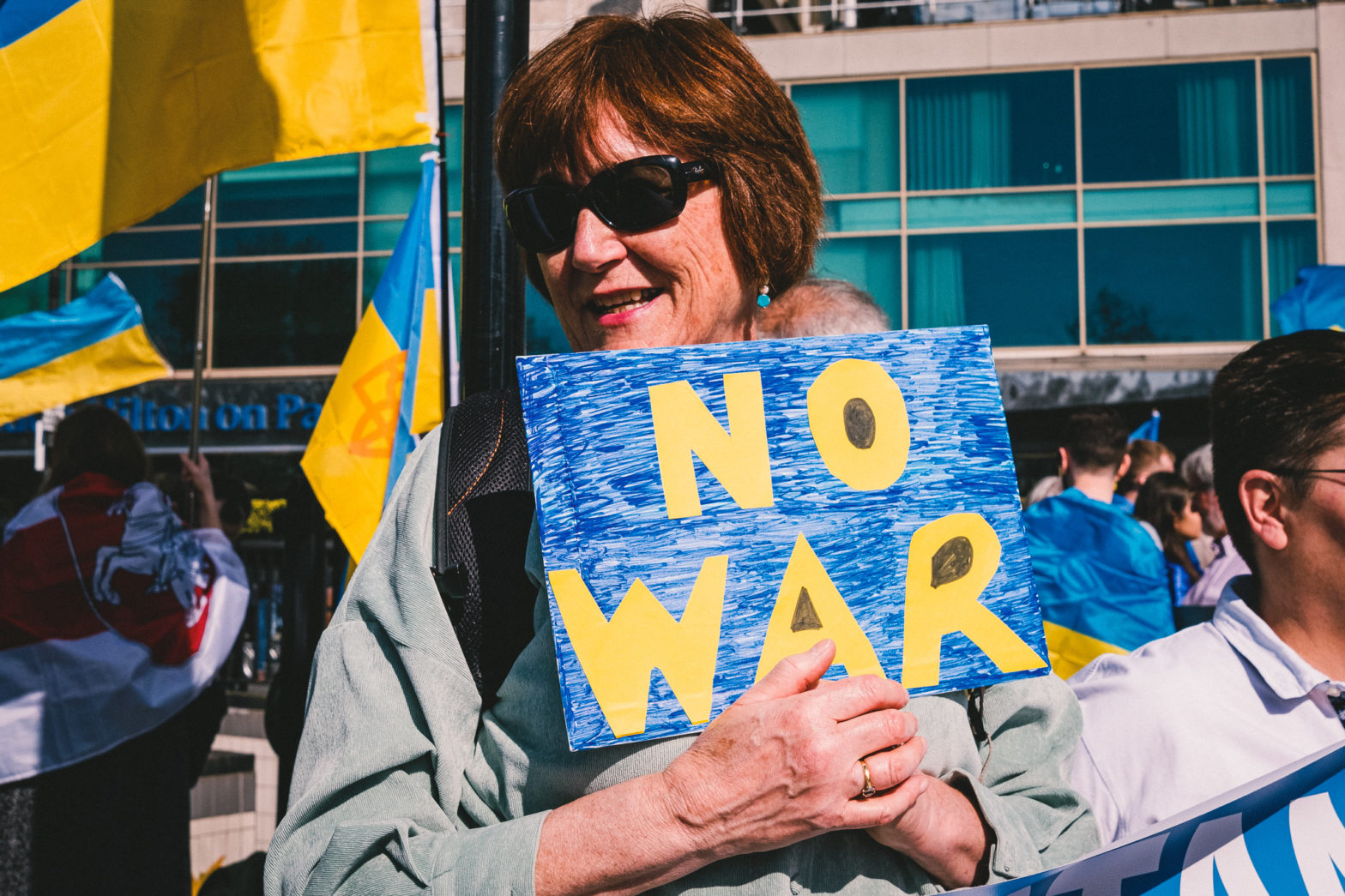 A protester holding a sign that reads: “No War” in the colours of Ukrainian flag