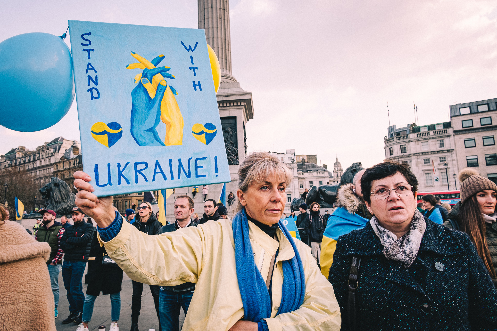 A protester holding a sign that reads: "Stand with Ukraine"