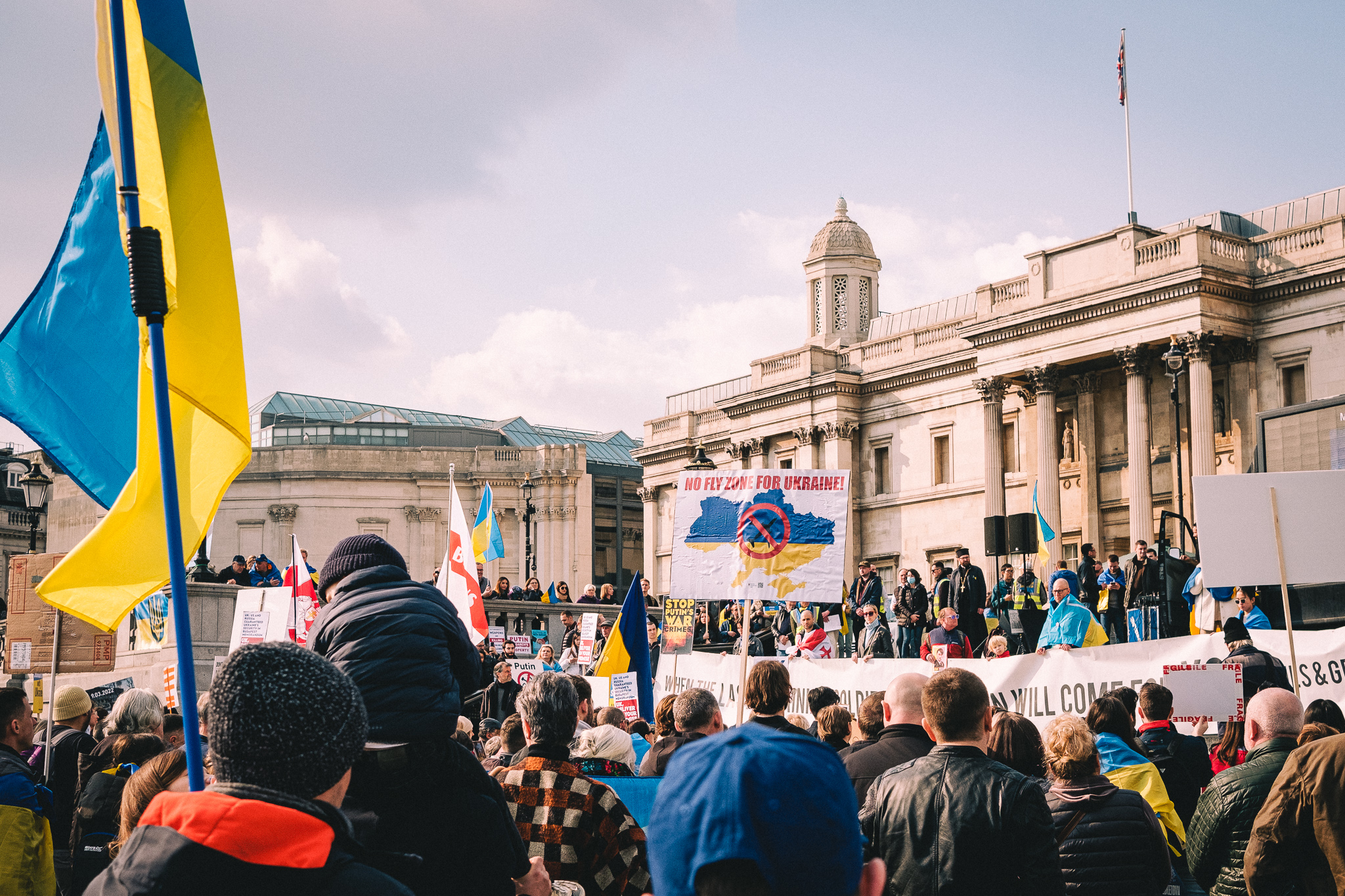 A group of protesters at the rally to support Ukraine at Trafalgar Square holding sings and banners