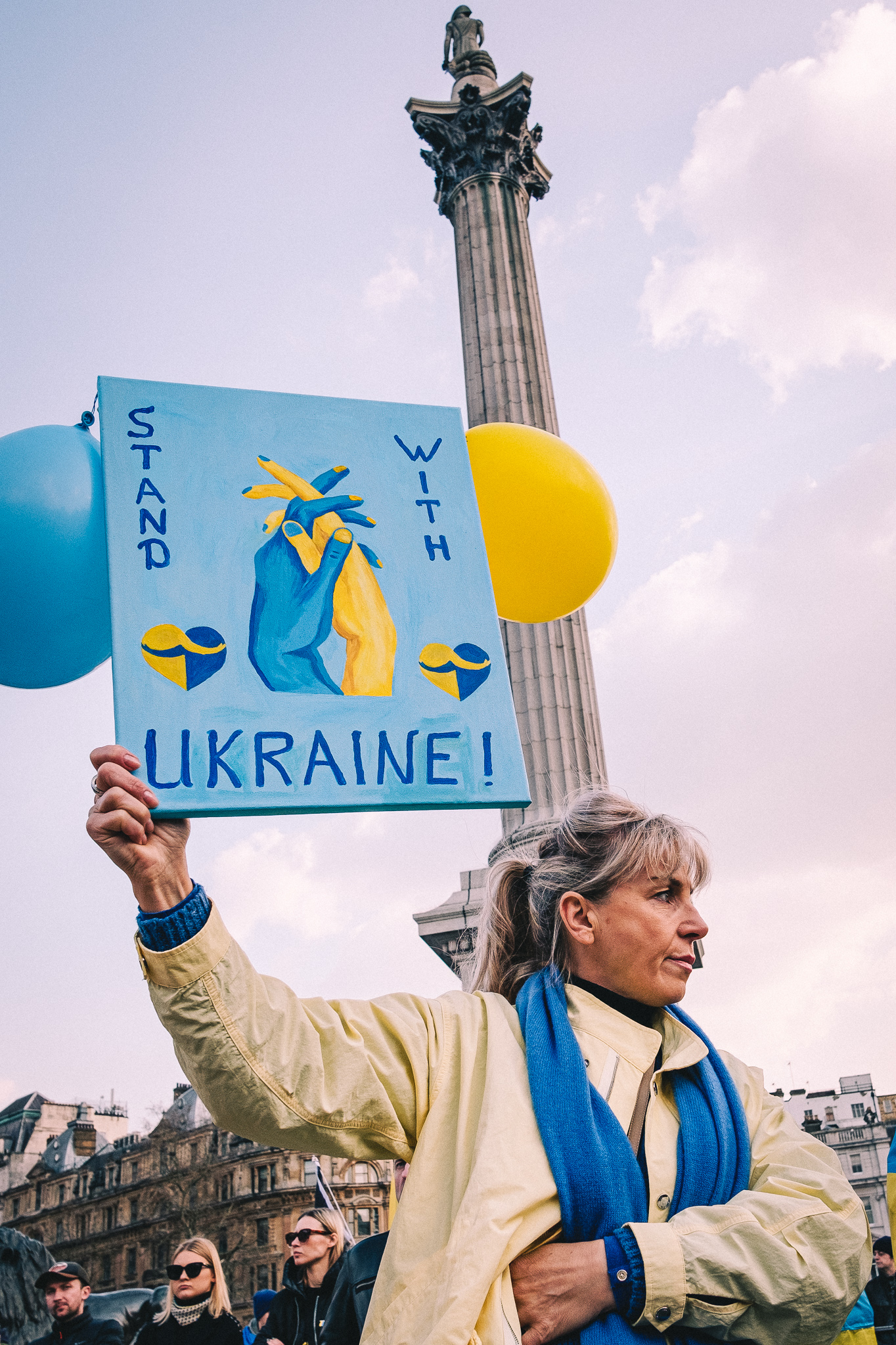 A protester holding a sign that reads: "Stand with Ukraine"