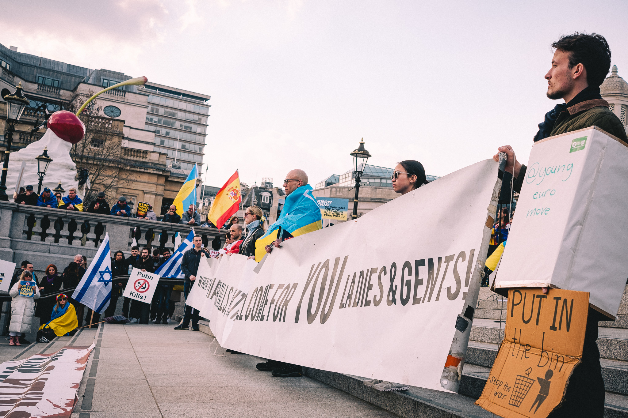 A group of protesters at the rally to support Ukraine at Trafalgar Square holding sings and banners