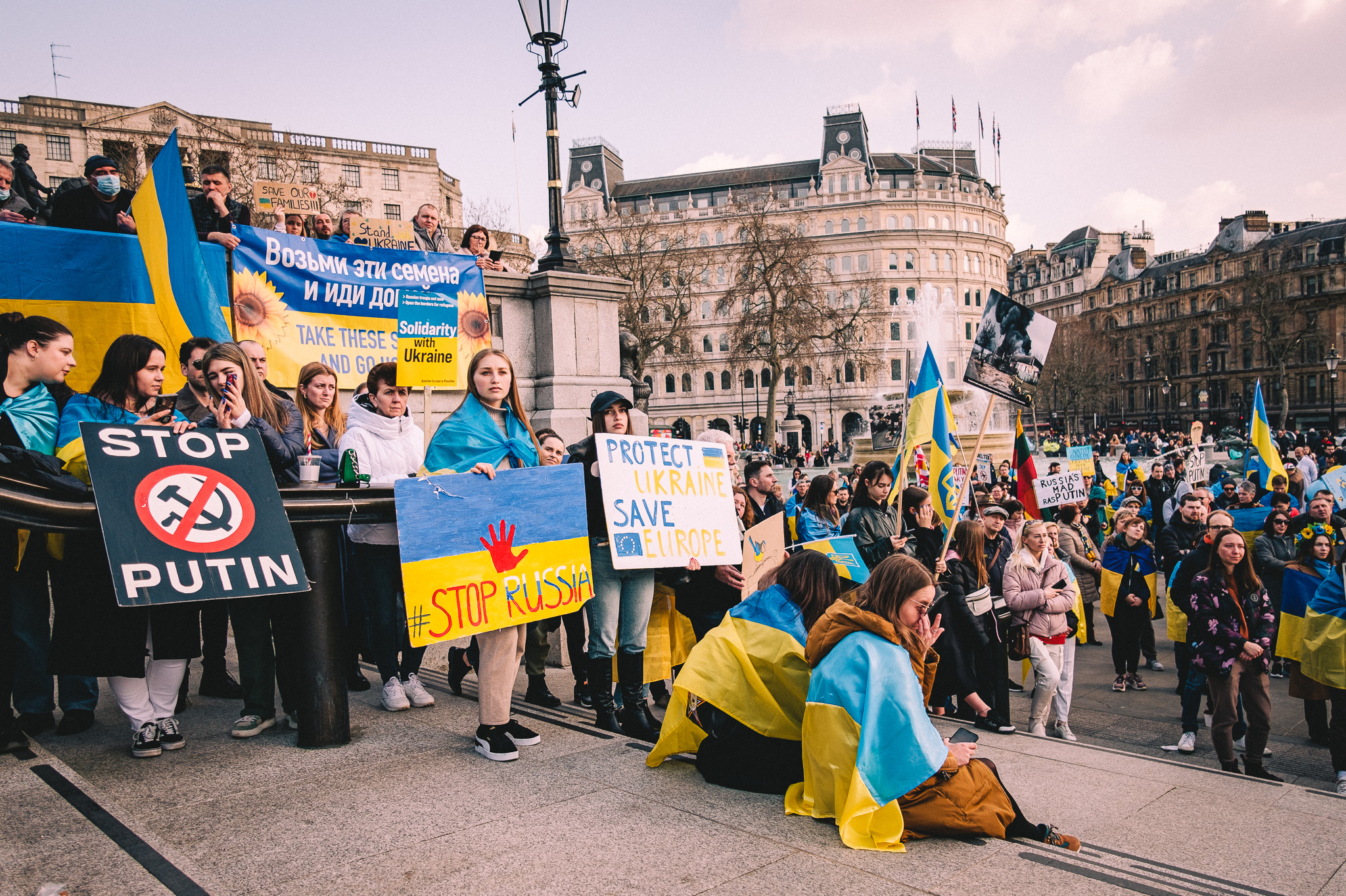 A group of protesters at Trafalgar Square holding sings: Stop Putin, Stop Russia