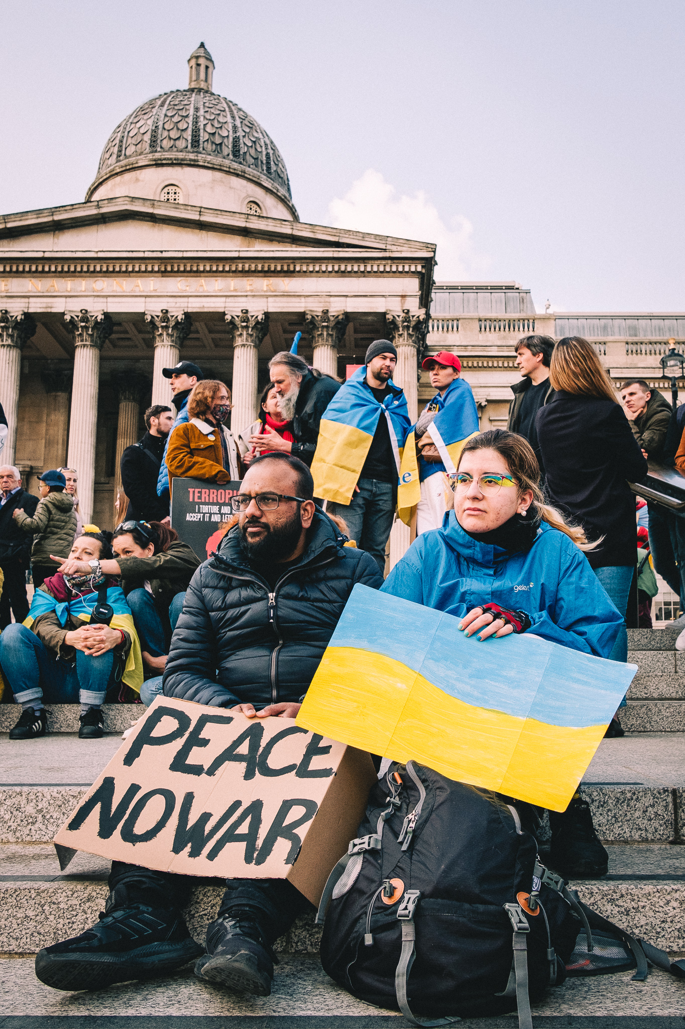 A group of protesters siting on the steps of the The National Gallery at the rally to support Ukraine